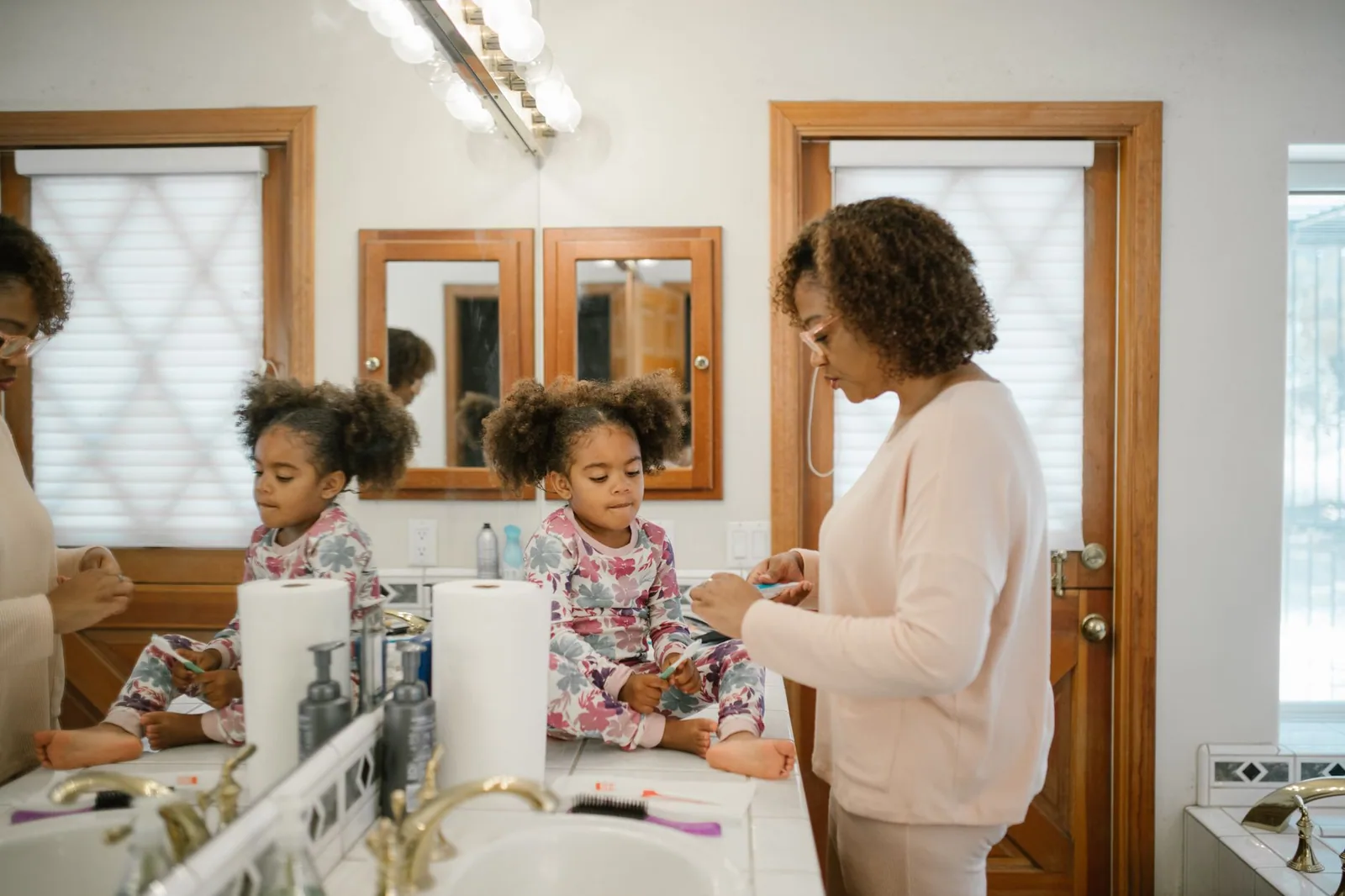 A parent and child at a bathroom sink during the morning routine