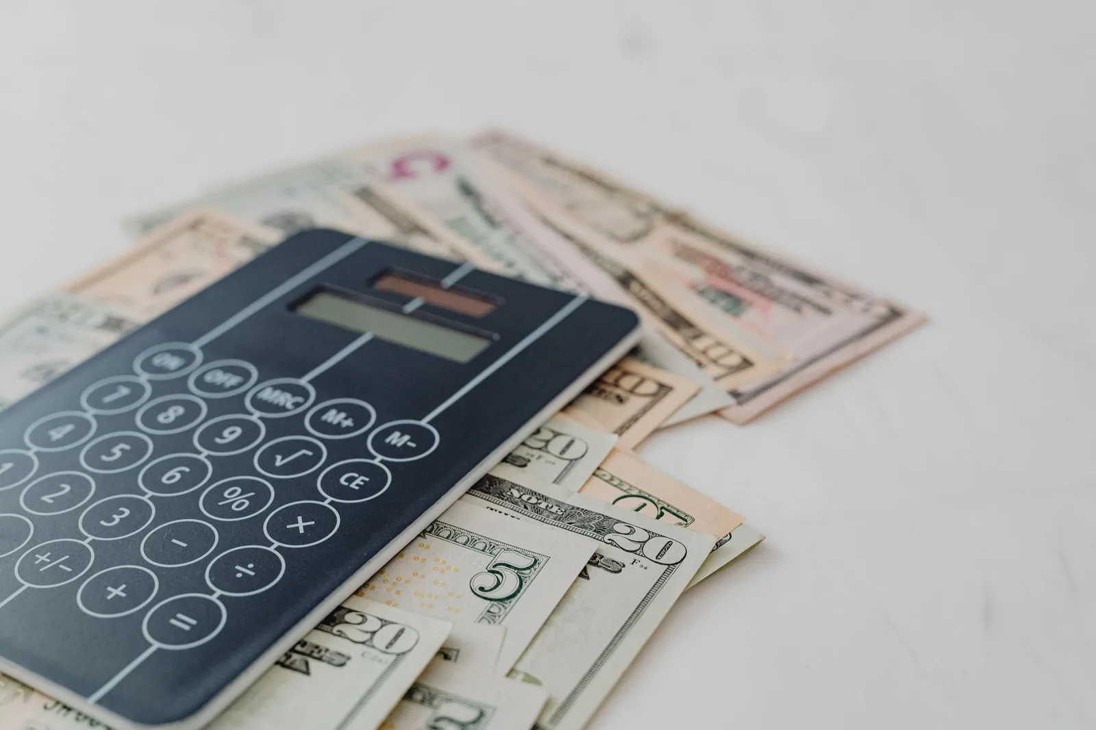 A calculator resting on a stack of US dollar bills