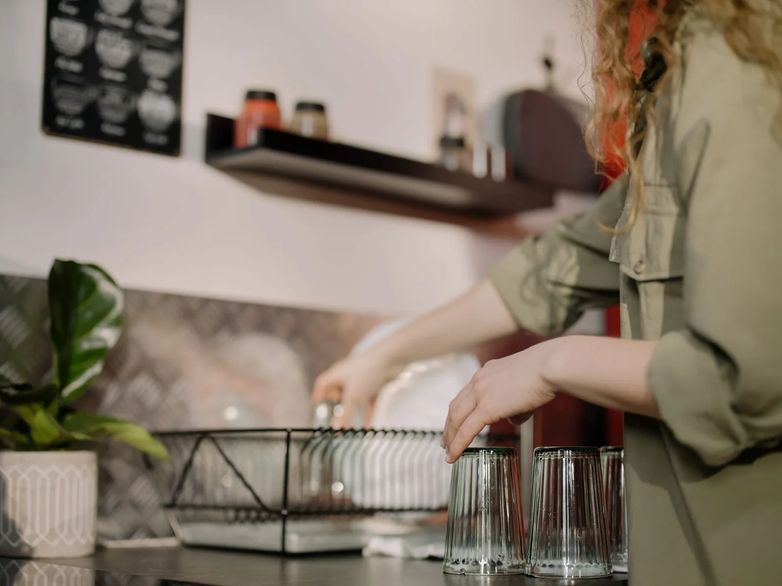 Clean drinking glasses set upside down to dry beside a dish rack