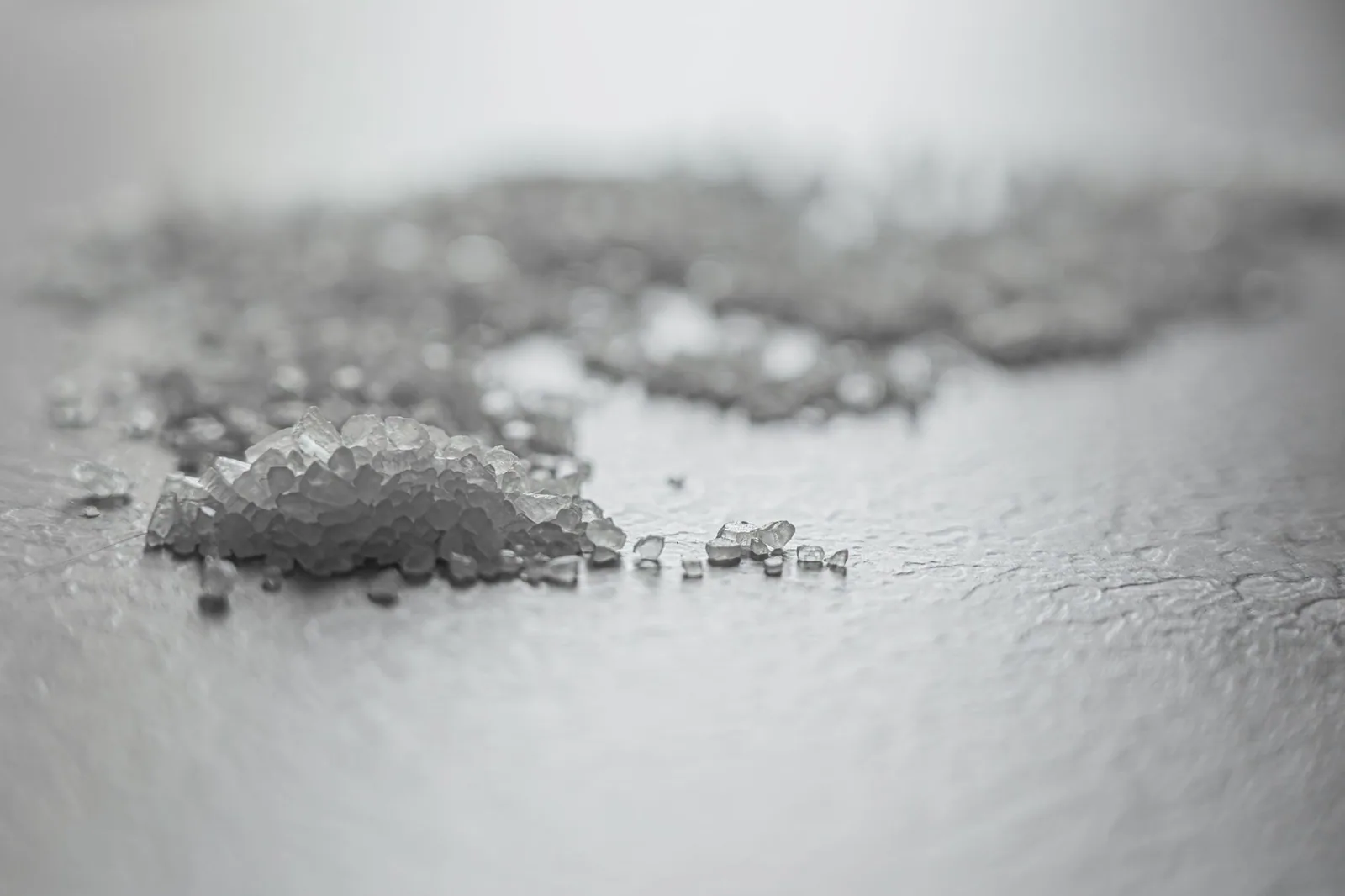 Coarse salt crystals shot close up, showing the irregular grain of solar salt