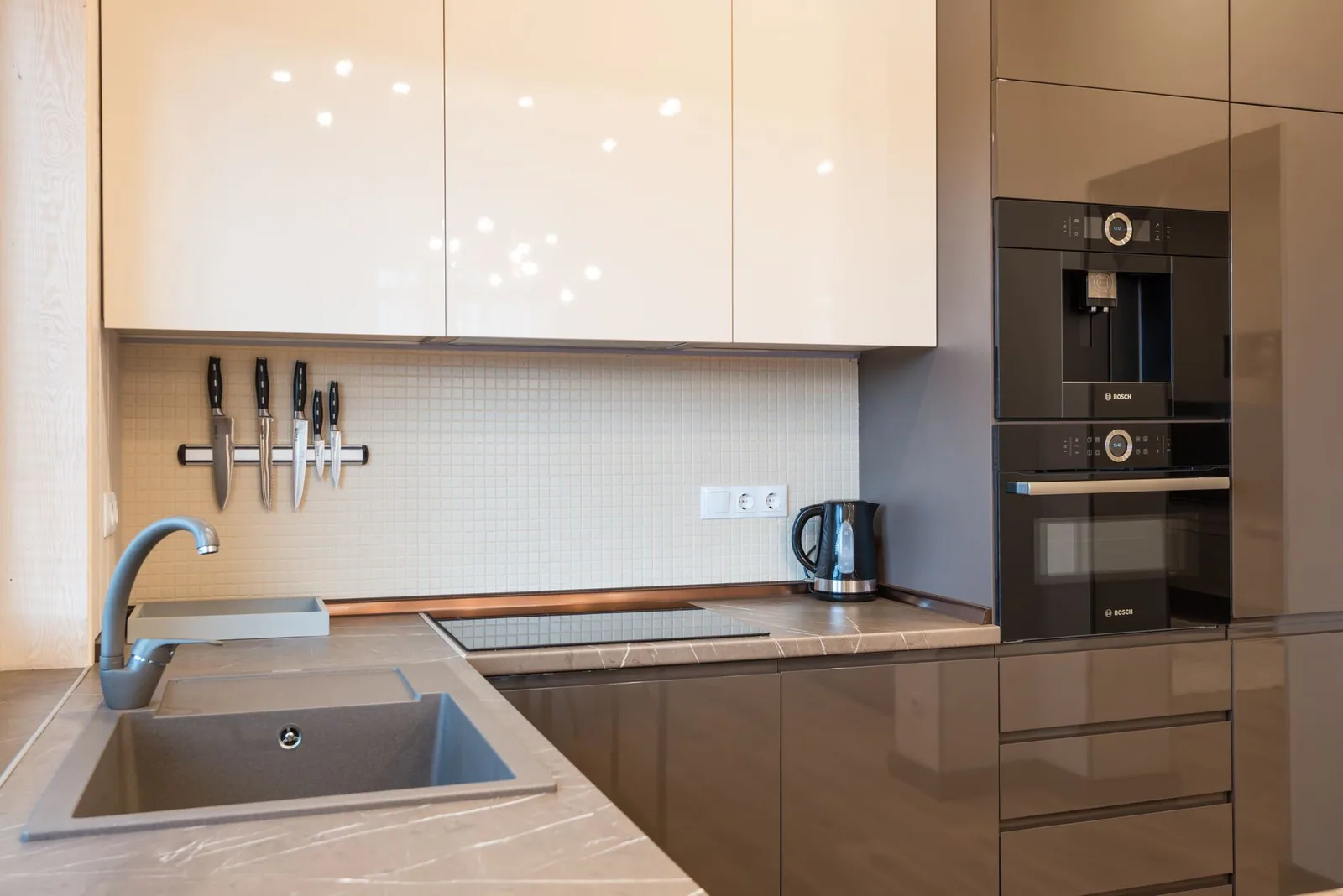 A light contemporary kitchen with glossy cabinets and built-in appliances