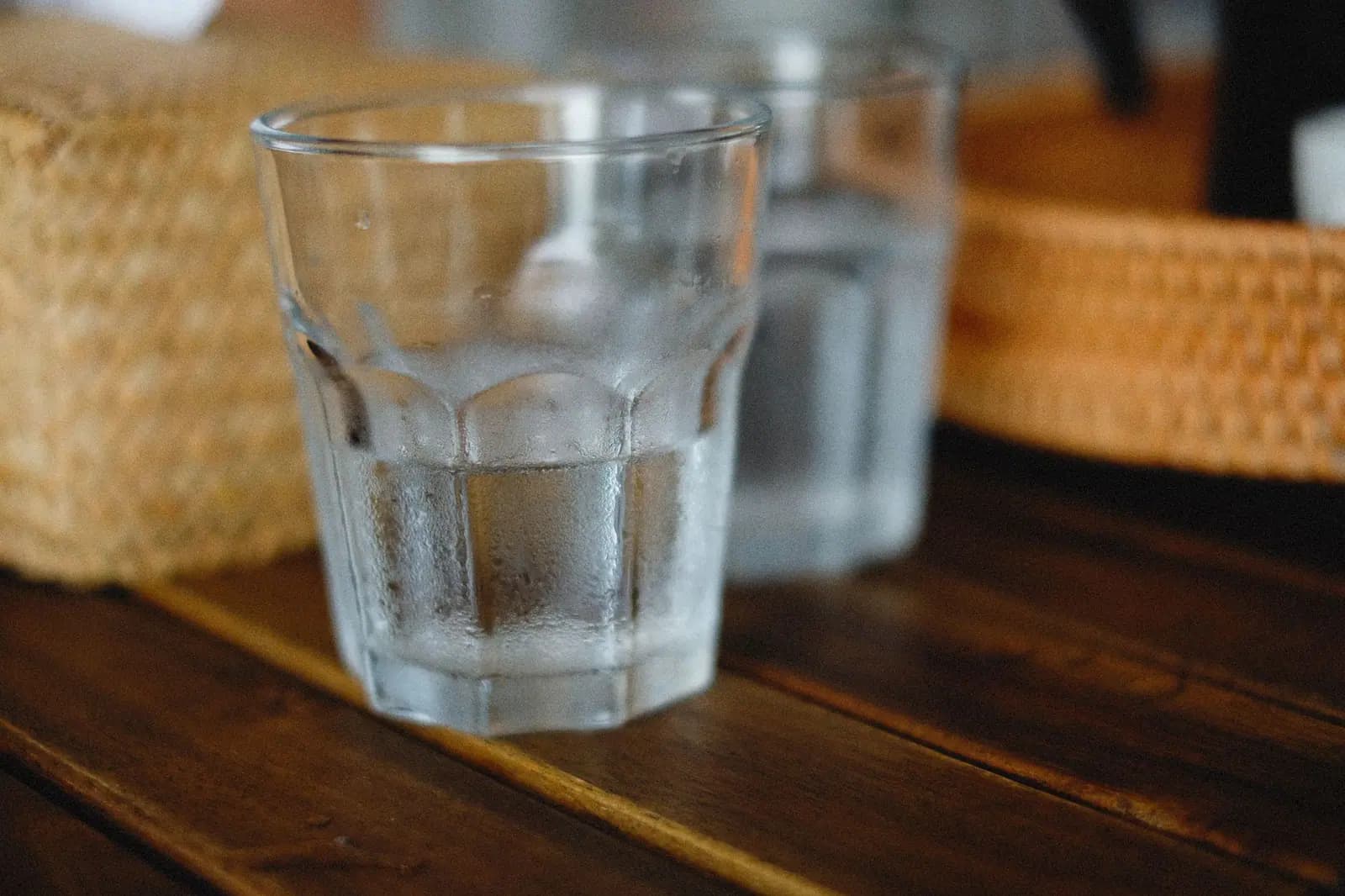 A glass of cold water on a rustic wooden table