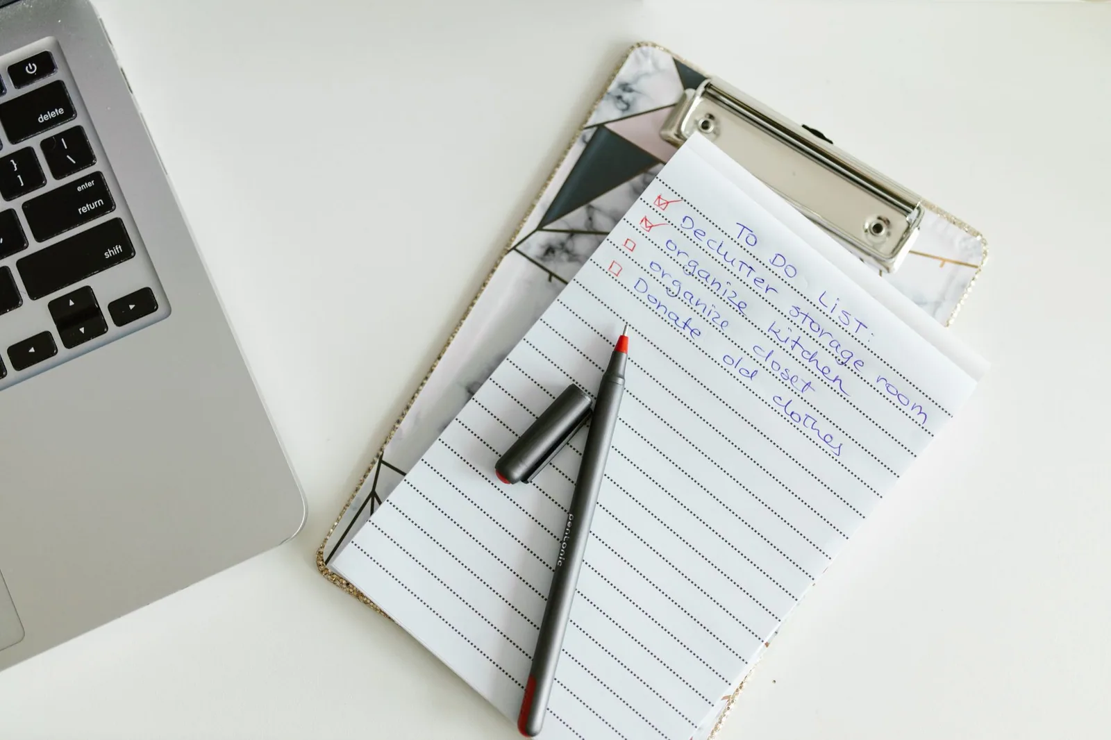 A written checklist on a clipboard with a pen laid across it