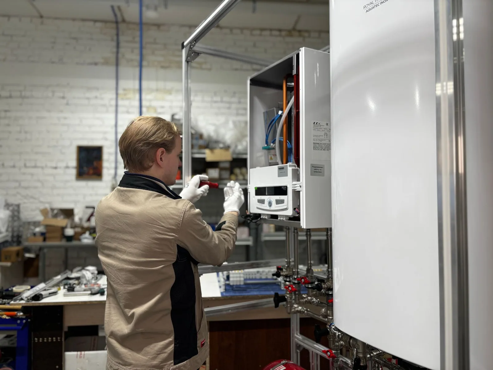 A technician working on pipework with hand tools