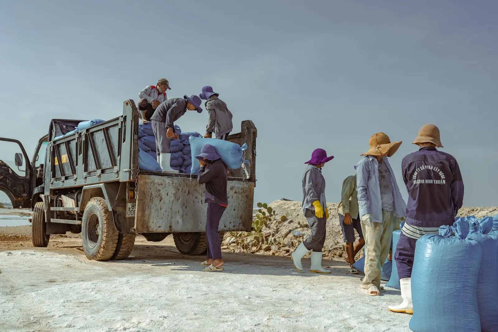 Workers unloading bags of salt from a delivery truck
